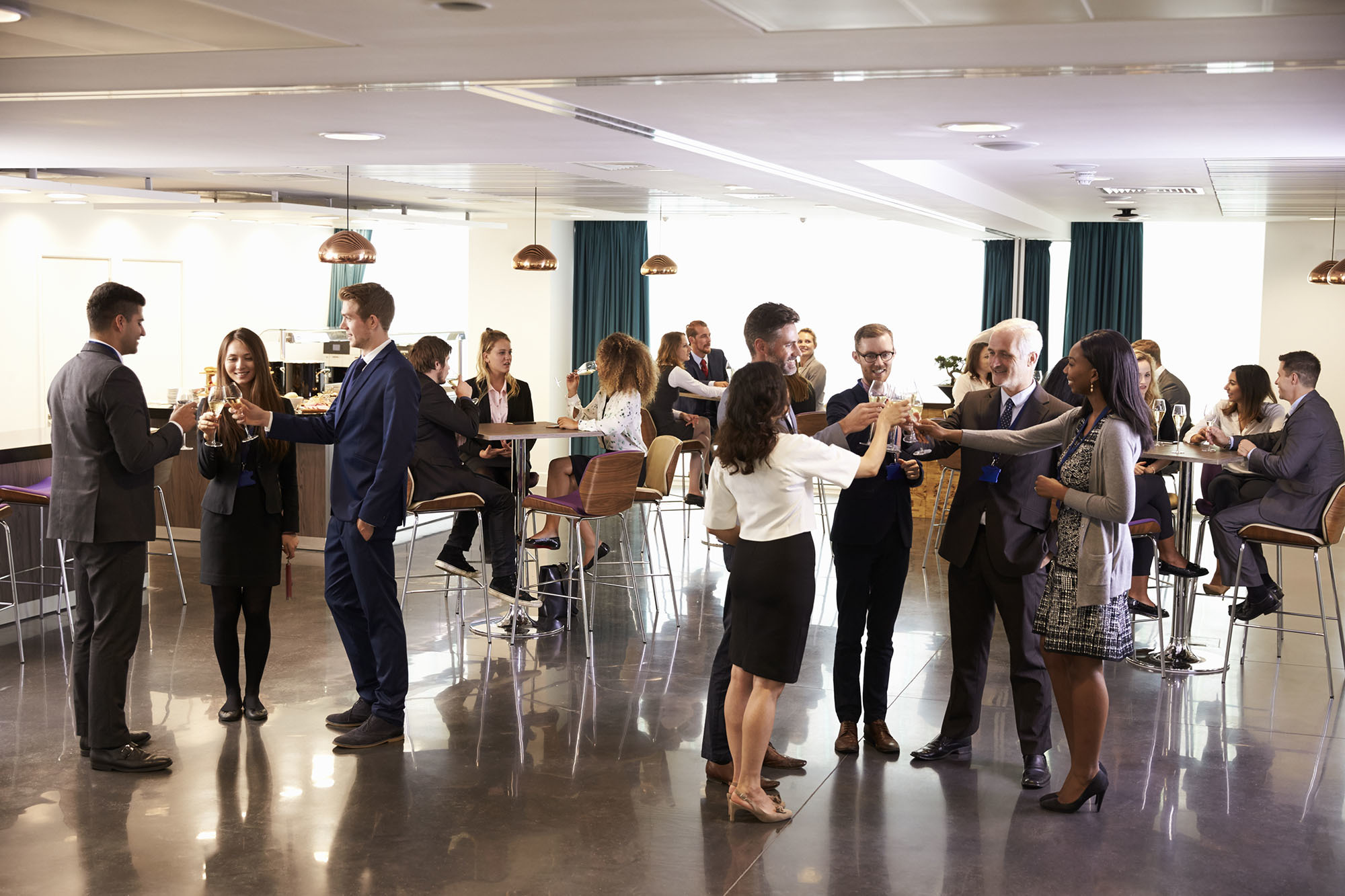 Professionelles Networking-Event in der Versicherungsbranche: Mitarbeiter und Gäste feiern mit Gläsern in einem modernen Büro-Raum, was für eine starke Arbeitgebermarke steht.