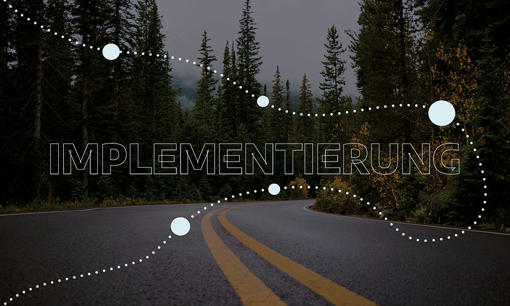 Ein Bild einer gewundenen Straße durch einen Wald mit dem Wort 'IMPLEMENTIERUNG' symbolisiert den Prozess der Projektumsetzung und Markenstrategien.