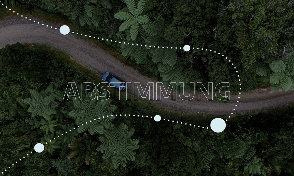 Luftaufnahme eines sich schlängelnden Feldwegs durch einen üppigen Wald, ergänzt um ein blaues Auto, punktierte Führungslinien und den Schriftzug „ABSTIMMUNG“ – als Symbol für die kreativen Strategien von N3W für eine klare, effektive Markenkommunikation.